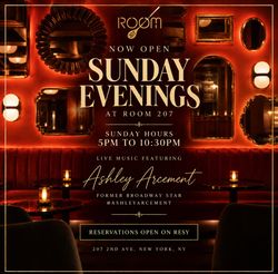 Cozy bar interior with red velvet seating and vintage mirrors, hosting live music on Sunday evenings at Room 207.